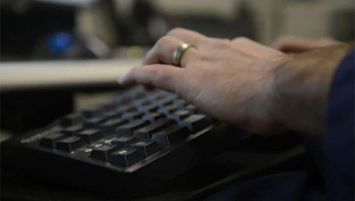 Hands typing on a computer