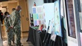 Service members look at art included in the Healing Arts Exhibit on display throughout November at Walter Reed National Military Medical Center.