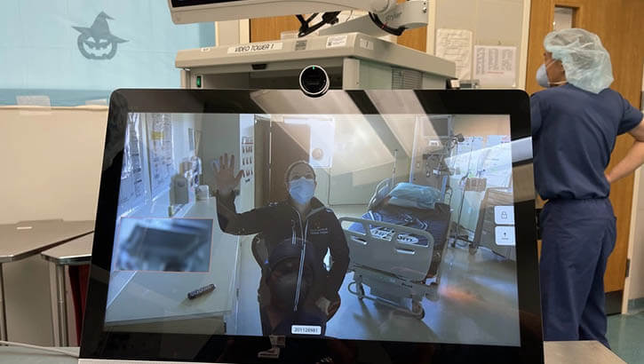 Image of Navy Lt. Cmdr. Kathryn Lipscomb, the urology department head at U.S. Naval Hospital Rota in Spain, waves to staff in USNH Naples, Italy during the first virtual cystoscopy between both hospitals in Jan 2021. (Photo: Navy Cmdr. Ryan Nations).