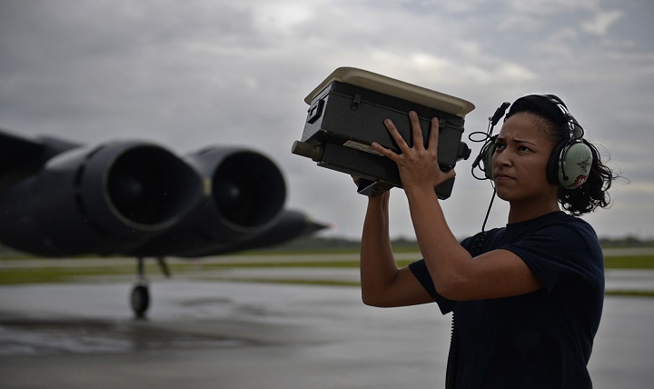 Senior Airman Alexandra Washington, communications and navigations technician assigned to the 20th Expeditionary Aircraft Maintenance Squadron, checks antennae signals on a B-52 Stratofortress, while wearing hearing protection. 