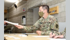 Army Col. Richard Hopkins, the COVID-19 response coordinator with Weed Army Community Hospital, collects paperwork from a Soldier who received the COVID-19 vaccine at a vaccination event.