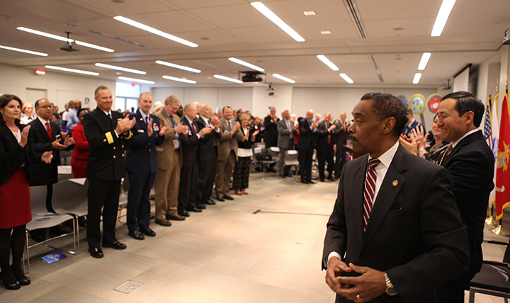 Senior military medical leaders and staff of the Military Health System stand to applaud Dr. Jonathan Woodson, who is stepping down as assistant secretary of Defense for Health Affairs after nearly six years of service. 