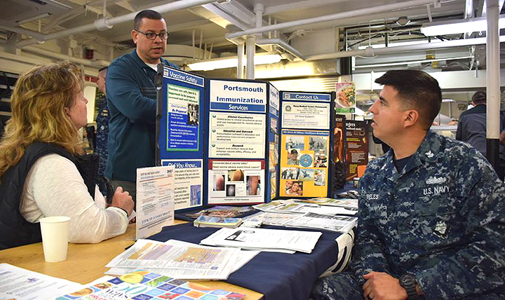 Immunization Healthcare Branch nurse practitioner Ann Morse (left) speaks to Sailors about immunizations at a health fair. The Health Fair was part of a long-range plan to improve the overall health and wellness of Sailors.(U.S. Navy photo by Lt. j.g. Mckensey Smith)