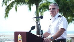 A man speaks into a microphone on a podium