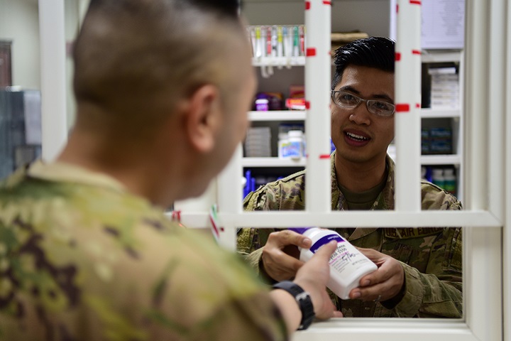 Air Force Tech. Sgt. Julian Tayag, the noncommissioned officer-in-charge of the 386th Expeditionary Medical Group pharmacy, provides medication to a coworker at an undisclosed location in Southwest Asia, recently. In early May, Tayag was selected to attend the Interservice Physician Assistant Program. (Air Force photo by Staff Sgt. Christopher Stoltz)