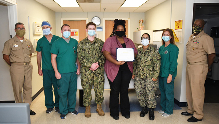 Naval Medical Center Camp Lejeune staff stand with award from the Joint Outpatient Experience Survey.