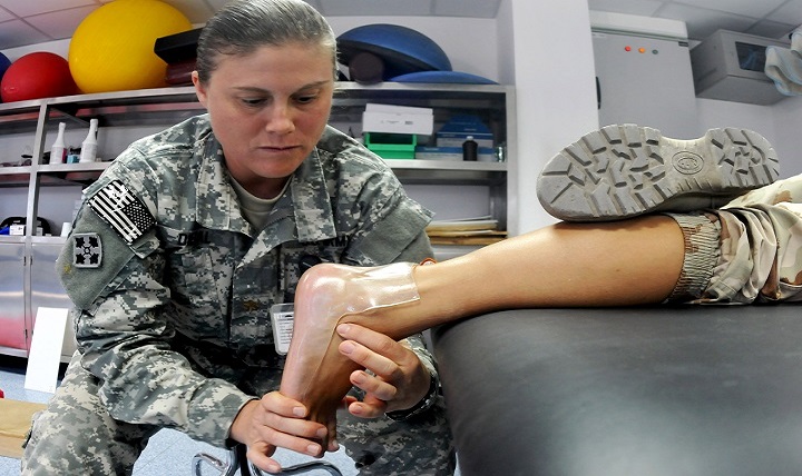 Army Maj. Angela Diebal, a physical therapist, customizes an orthotic device for her patient. 
