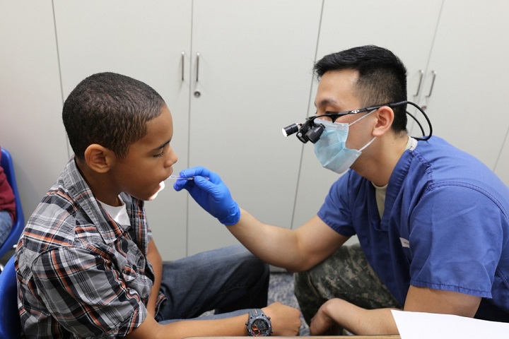 Jordyn Pafford, sixth grader, receives a dental screening conducted by Capt. James Lee, a general dentist. (U.S. Army photo by Lance D. Davis) 