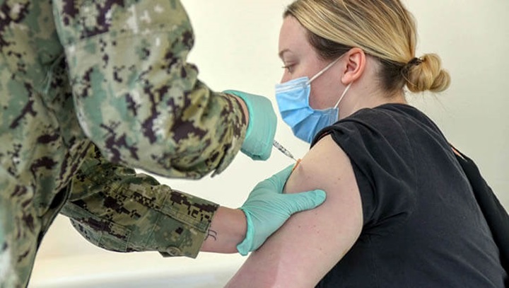 Image of FEmale Marine gets COVID 19 vaccination in left  arm at Camp LeJeune in December 2020.