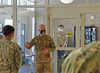 Military personnel wearing face masks speaking