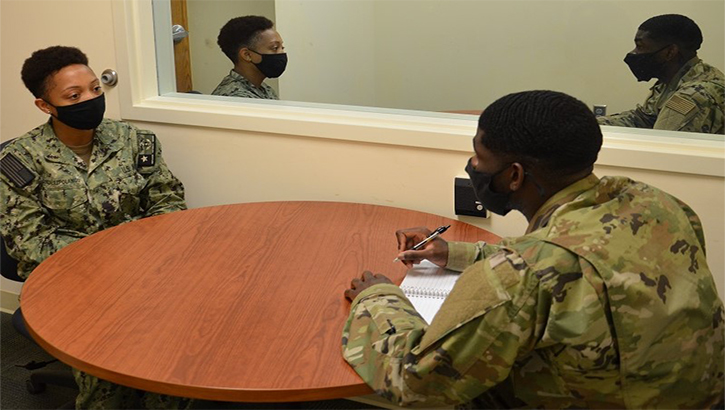 Two servicemembers talking at a table