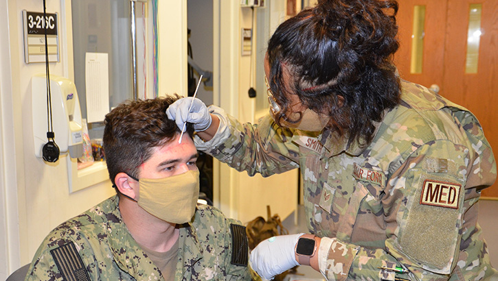 Image of Military health personnel wearing face mask practicing using an EEG . Click to open a larger version of the image.
