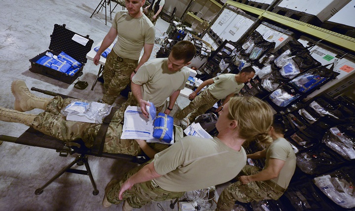 Airmen from the 379th Expeditionary Medical Group Mobile Field Surgical Team discuss the actions and supplies needed during a timed training scenario to help with familiarization training August 28, 2015 at Al Udeid Air Base, Qatar. 