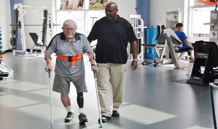 Physical therapy technician Troy Hopkins assists retired Maj. Gen. William L. Moore Jr. at the Center for the Intrepid, Brooke Army Medical Center’s outpatient rehabilitation facility on Joint Base San Antonio-Fort Sam Houston in San Antonio.