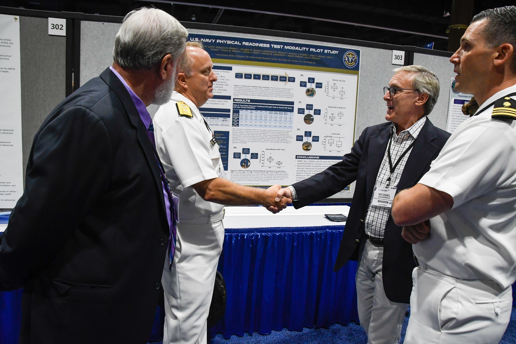 Navy Rear Adm. Darin K. Via, deputy chief, Readiness and Health, Bureau of Medicine and Surgery, meets with Mr. Mike Galarneau, director, Operational Readiness & Health, Naval Health Research Center, during poster presentations while attending MHSRS 2019. (U.S. Navy photo by John Marciano)