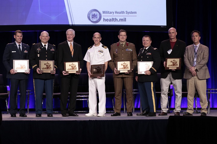 Pictured are the recipients of the 2018 MHSRS Awards, including the 2018 MHSRS Distinguished Service Award, the individual achievement in research awards, and the research team awards. Right to left are Air Force Maj. Joseph K. Maddry, Army Col. Michael P. Kozar, Kenneth M. Hargreaves, DDS, Ph.D., Navy Lt. Cmdr. Micah Gaspary, Australian Defence Force Col. Michael Reade, Army Col. Andrew P. Cap, Dr. Thomas Joiner and Dr. Peter Gutierrez. (MHS photo)