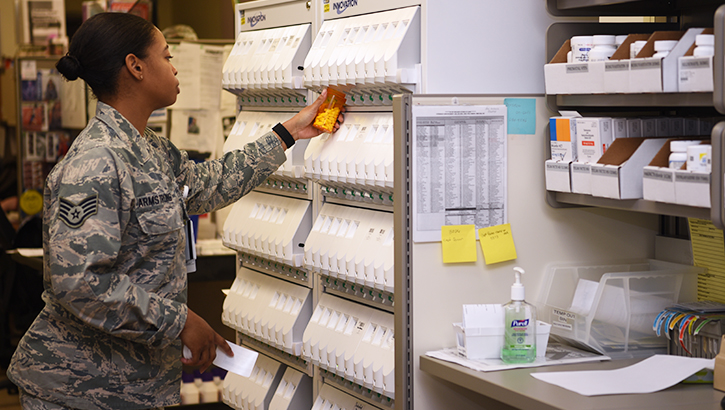 A military pharmacist choosing medication from a shelf