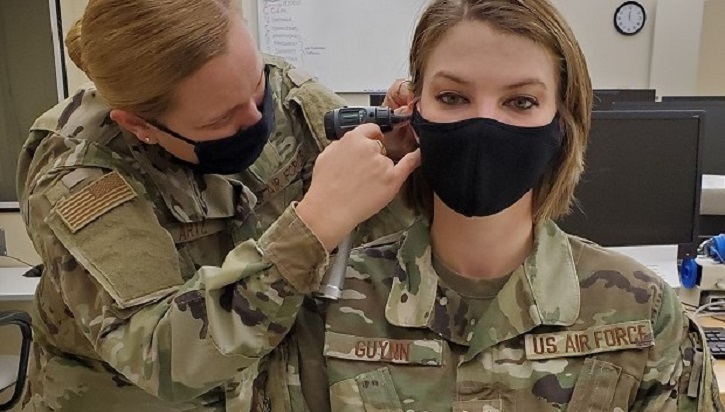 Image of Military doctor inspecting patient's ear.