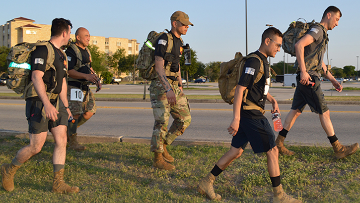 Image of Military personnel walking in the grass. Click to open a larger version of the image.