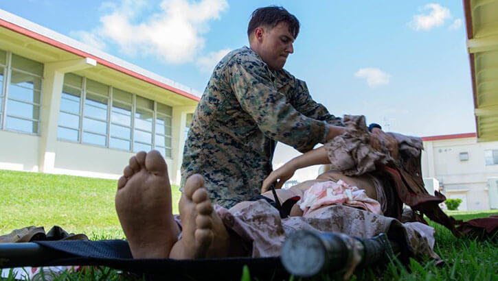 A Marine practices Tactical Combat Causality Care on a simulated casualty during a TCCC course on Camp Hansen.