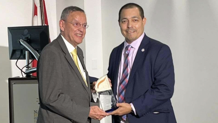 Image of Assistant Secretary of Defense for Health Affairs Dr. Lester Martínez-López (left) receives the National Health IT Collaborative Health Equity and Inclusiveness Award for Excellence in Public Service at its 15th anniversary reception on Sept. 20, 2023, in Washington, D.C.  Presenting the award is Luis Belen, chief executive officer, National Health IT Collaborative for the Underserved.  (Courtesy photo).