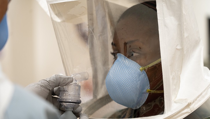 Image of soldier in a hazmat suit with a medical-grade mask. Click to open a larger version of the image.