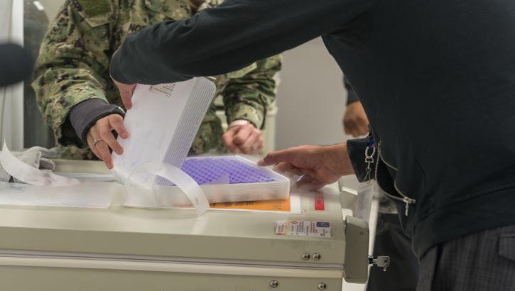 Image of Military personnel getting COVID-19 vaccines ready.