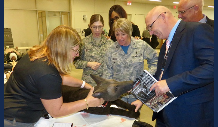 Air Force Col. Christine Kress (center) observes use of a medical canine mannequin designed to create training environments that prepare medical professionals for events they may face in the field. (MHS photo)