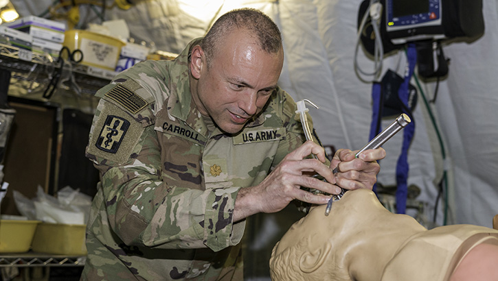 Military medical personnel demonstrating a surgical technique