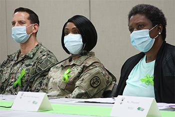 Military personnel wearing face mask speaking on a panel