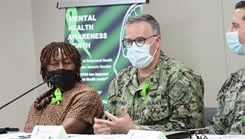 Military personnel wearing face mask speaking on a panel