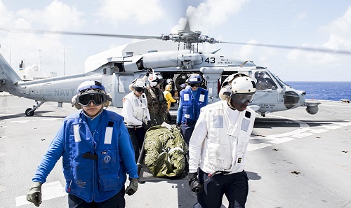 Sailors transport a mock patient from an MH-60S Sea Hawk helicopter, attached to the “Wildcards” of Helicopter Sea Combat Squadron 23, to the triage center during a mass casualty integrated field exercise aboard the hospital ship USNS Mercy during Pacific Partnership 2018. (U.S. Navy photo by Mass Communication 2nd Class Kelsey L. Adams)