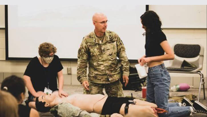 A soldier trains civilian medical students.