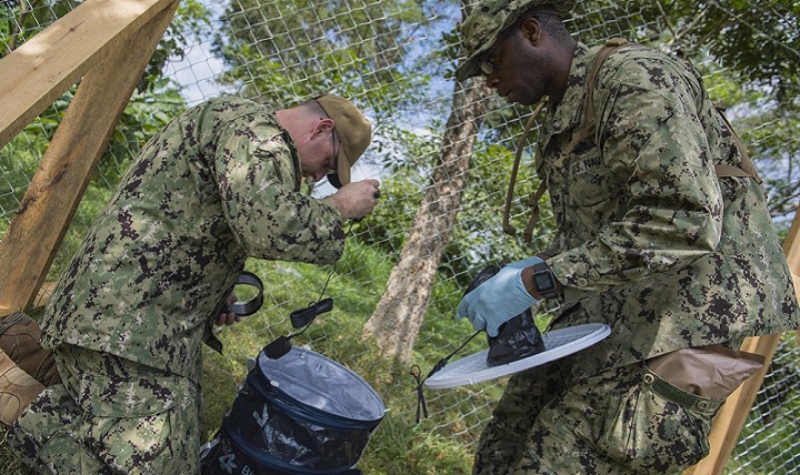 Navy Lt. Marcus McDonough and Navy Hospital Corpsman 1st Class Adrian Weldon, assigned to Navy Environmental and Preventative Medicine Unit TWO, prepare a BG-Sentinel mosquito trap outside the Franklin D. Roosevelt School during Continuing Promise 2018.(U.S. Navy photo by Mass Communication Specialist 2nd Class Brianna K. Green)