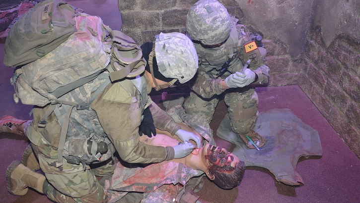 Combat Medic Training program students at the Medical Education and Training Campus at Joint Base San Antonio-Fort Sam Houston conduct an emergency cricothyrotomy on a “casualty” during simulation training. The “wounded” manikin also presents with facial burns that were created with moulage techniques. (DoD photo by Lisa Braun)