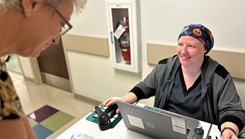 Michelle Grant, a public health nurse at Munson Army Health Center, Fort Leavenworth, Kansas, checks co-worker, Karen King, in for her flu shot, Oct. 9. Grant is currently undergoing treatment for breast cancer and shared her journey so that others understand the importance of regular mammograms. (Photo by Maria Christina Yager/Munson Army Health Center Public Affairs) 