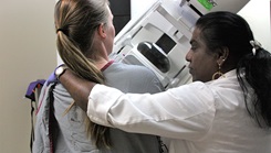 Military medical personnel performing mammogram