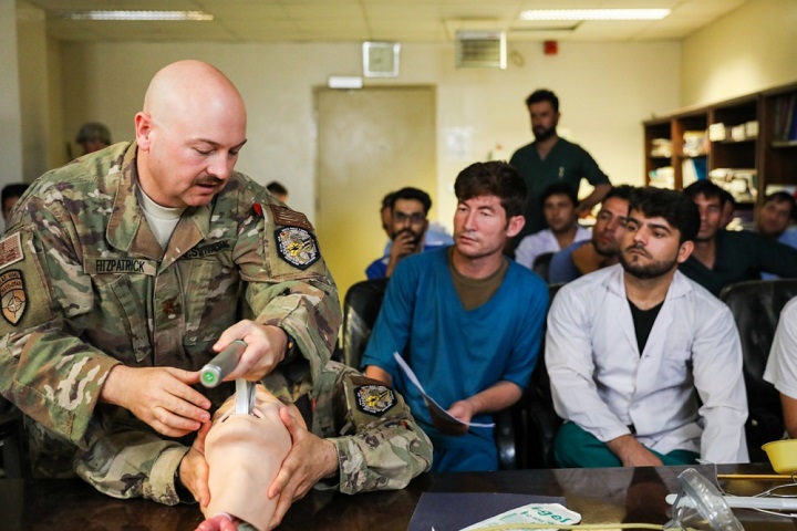 Navy Lt. Cdr. Travis J. Fitzpatrick, senior nurse for Kandahar Airfield NATO Role III Multinational Medical Unit, demonstrates a technique on how to clear the airway of a patient to Afghan medical staff members during a medical advisory visit at Kandahar Regional Military Hospital, Camp Hero in Kandahar, Afghanistan. Staff members from the Role III conduct routine visits to KRMH to train and advise Afghan medical staff. (U.S. Army photo by Staff Sgt. Neysa Canfield)