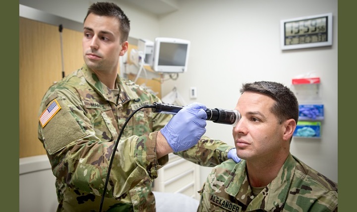 In a demonstration of the telehealth process at Fort Campbell’s Blanchfield Army Community Hospital, clinical staff nurse Army Lt. Maxx Mamula examines mock patient Army Master Sgt. Jason Alexander using a digital external ocular camera. The image is immediately available to a provider at Fort Gordon’s Eisenhower Medical Center, offering remote consultation. (U.S. Army photo by David E. Gillespie)
