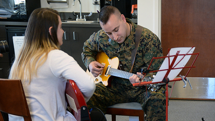 Image of U.S. Marine Staff Sgt. Anthony Mannino plays guitar as he receives music therapy as part of his traumatic brain injury treatment and recovery. Kalli Jermyn, a music therapy intern, observes, instructs, and works with Mannino. The therapy is conducted at the National Intrepid Center of Excellence, at the Walter Reed National Military Medical Center in Bethesda, Maryland. (Department of Defense photo by Marvin Lynchard).