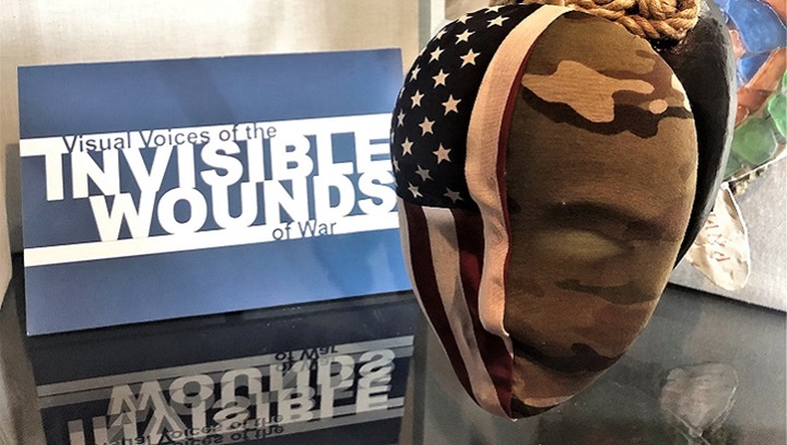 Image of Picture of a mask with the American flag on one side and camo on the other side.