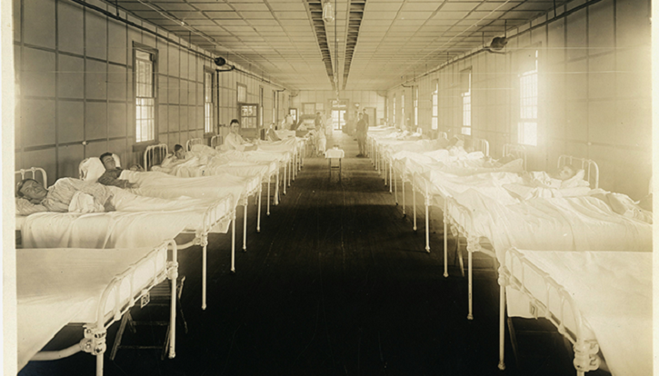 Image of two rows of empty hospital beds in the early 1900s