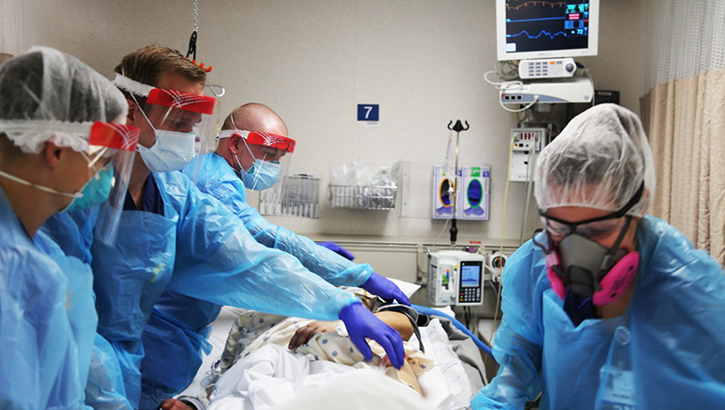 Image of medical personnel in a hospital room. Click to open a larger version of the image.