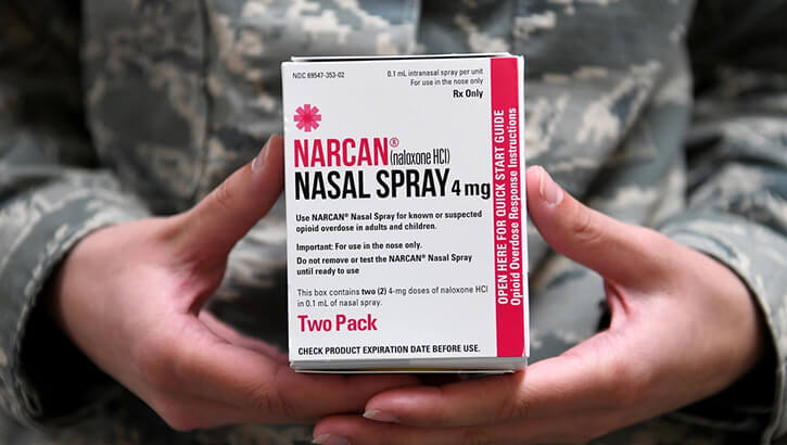Image of Airman holding a box of Narcan, an opioid overdose antidote called naloxone, in her hands.