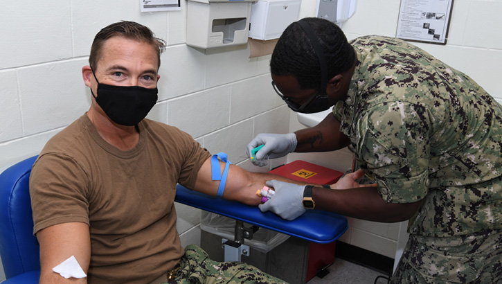 Image of Navy Capt. R. Wade Blizzard, commanding officer of U.S. Navy Support Facility Diego Garcia, donates blood for the Navy Medicine Readiness and Training Units Diego Garcia walking blood bank on Dec. 17, 2020. The walking blood bank is a list of eligible donors who can provide blood in case of emergency. (U.S. Navy photo by Navy Seaman Apprentice Stevin Atkins). Click to open a larger version of the image.