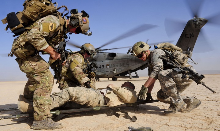 Air Force pararescuemen, 82nd Expeditionary Rescue Squadron, and a U.S. Army Site Security Team soldier, 2nd Battalion, 138th Field Artillery Regiment, load a mock isolated person onto a stretcher during a training exercise in the heat of the Grand Bara Desert, Djibouti. 