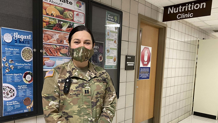 Military personnel wearing a face mask standing in front of a Nutrition Clinic