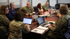 Military personnel sitting around a table talking