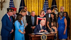 President talks to a child surrounded by a group of people.