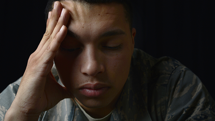 Image of a service member appearing distressed with hand on head. Click to open a larger version of the image.